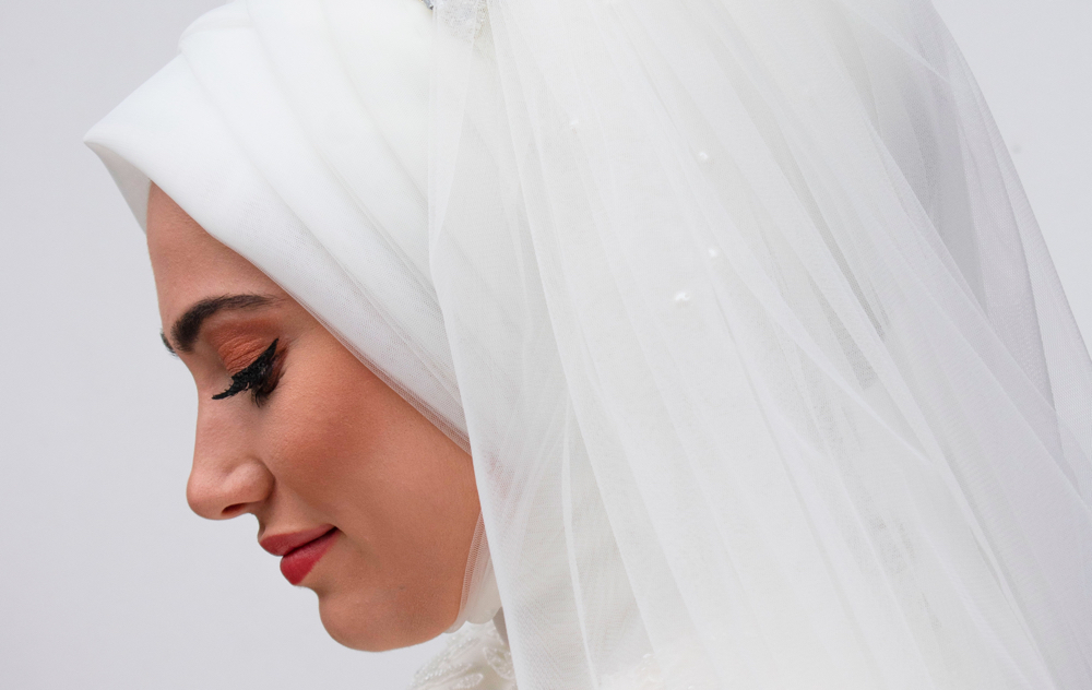 Side profile image of young muslim woman in white